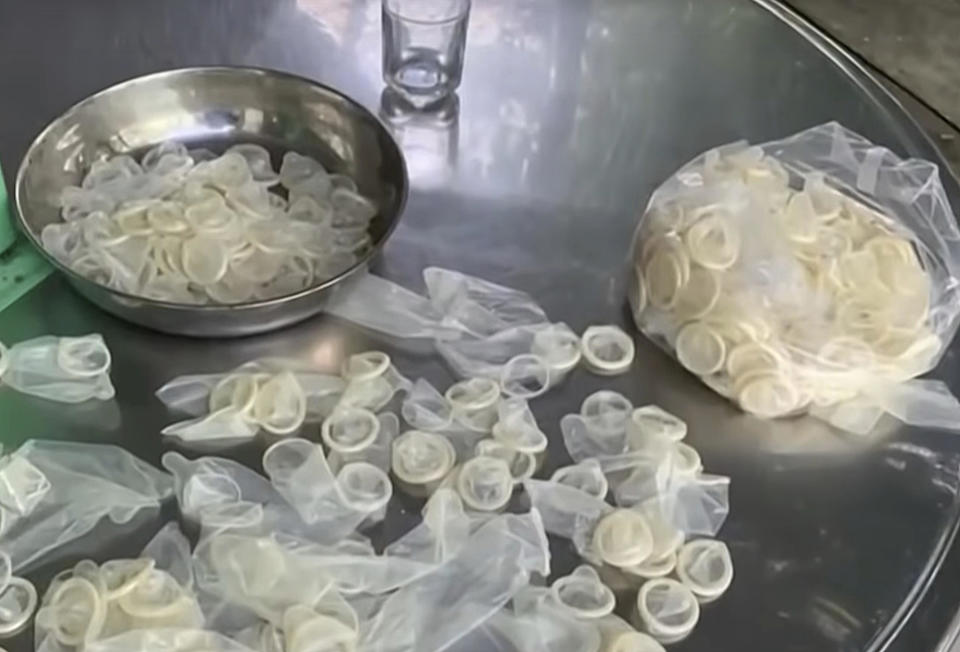 In this image from a video report by VTV, allegedly used condoms are being are being packed for sale in Binh Duong province, Vietnam on September 10, 2020.  / Credit: AP