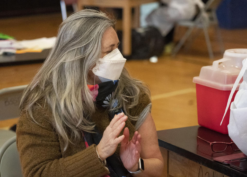 Teacher Lisa Egan claps after she receives the Moderna coronavirus vaccine at a clinic organized by New York City's Department of Health, Monday, Jan. 11, 2021. "I feel so great, so lucky," she said. "I've been teaching remotely. I'm hoping now I can go back to the classroom." Monday was the first day that people over 75 and essential workers — including police officers, firefighters, and teachers — were allowed to receive the vaccines in New York. (AP Photo/Mark Lennihan)