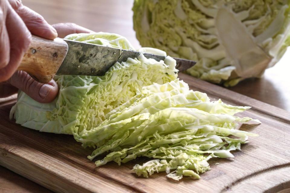 cabbage being sliced by a knife