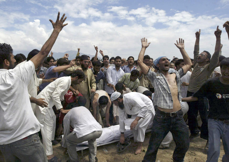 FILE - In this Aug. 14, 2008, file photo, Kashmiri Muslims shout slogans demanding independence from India as others prepare to carry the body of a man who was shot during a protest during his funeral in Srinagar, India. India's leaders are anxiously watching the Taliban takeover in Afghanistan, fearing that it will benefit their bitter rival Pakistan and feed a long-simmering insurgency in the disputed region of Kashmir, where militants already have a foothold. (AP Photo/Dar Yasin, File)