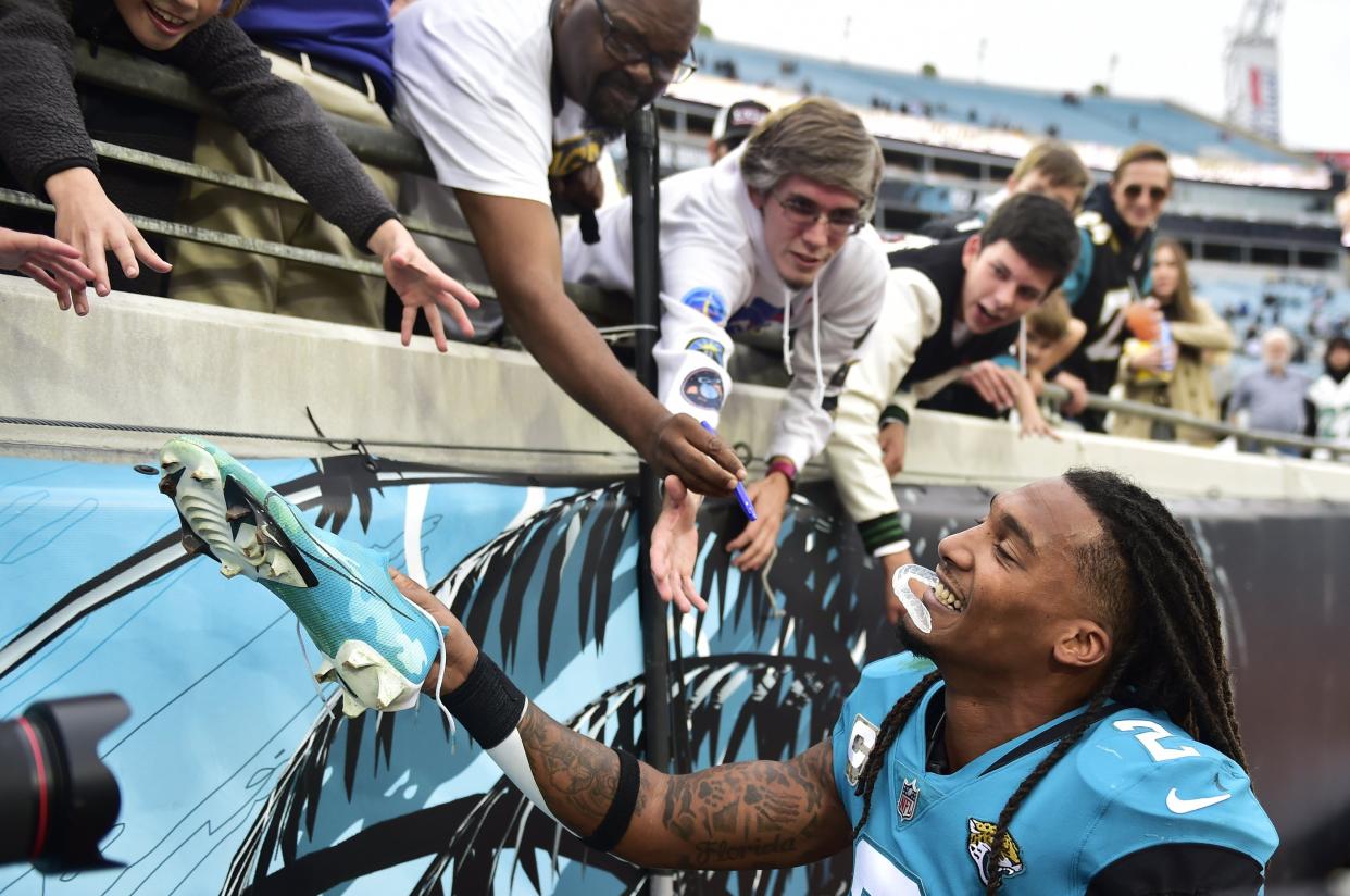 Jaguars safety Rayshawn Jenkins (2), seen here handing his game-worn cleats to fans last year after the Atlanta Falcons game, has an unusually large family and he spends big to get them tickets to home games.