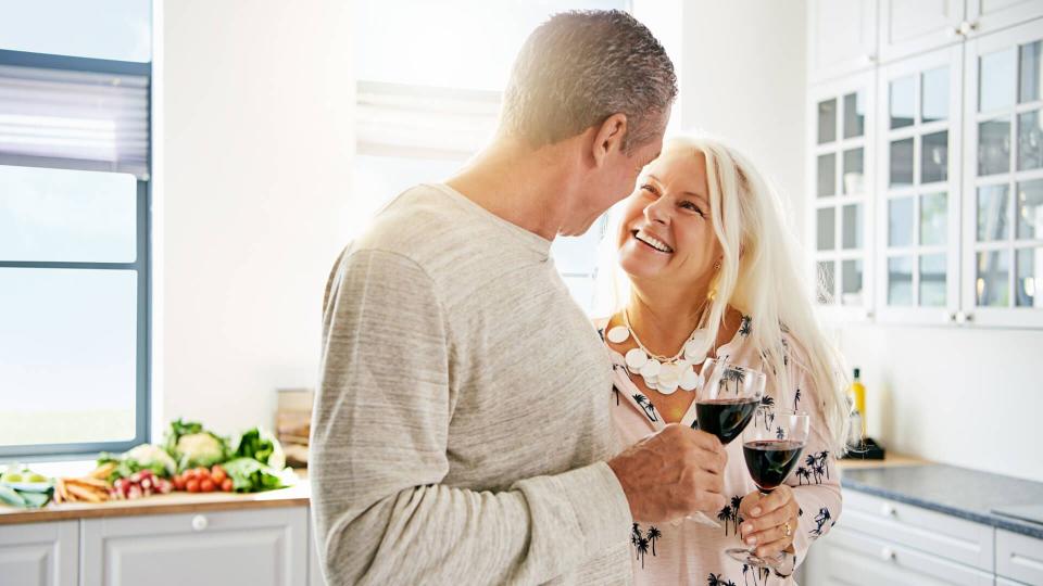 senior couple drinking wine in the kitchen together