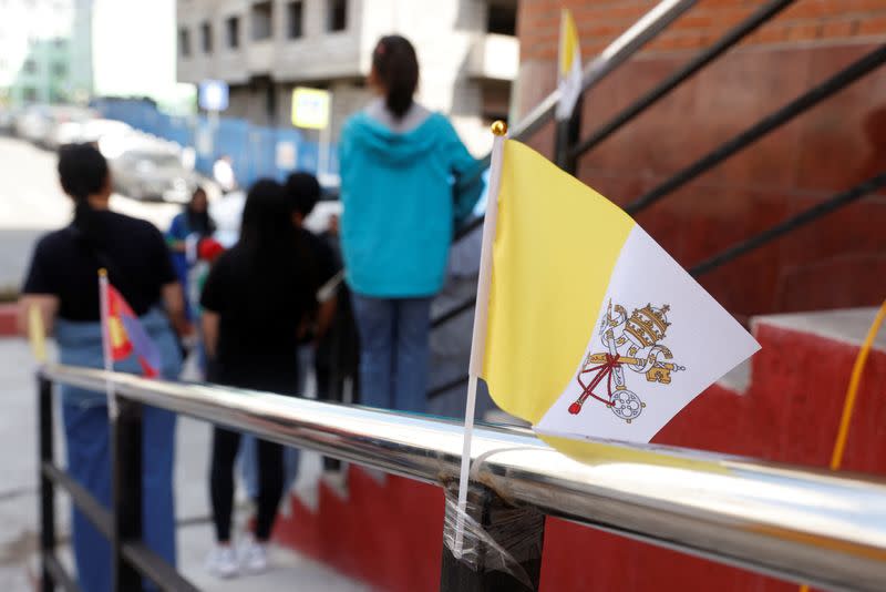 A Vatican City flag is pictured outside the bishop’s house, where Pope Francis is expected to stay during his Apostolic Journey, as people take part in a ceremony rehearsal one day ahead of his arrival in Ulaanbaatar