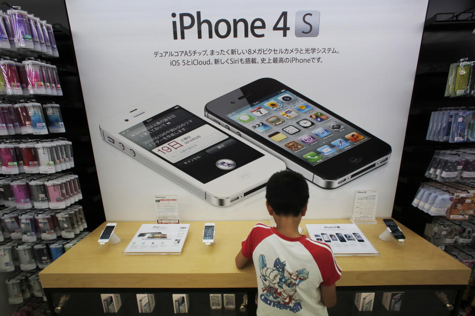 A boy checks an iPhone at an Apple booth at an electronic store in Tokyo Friday, Aug. 31, 2012. A Tokyo court has ruled that Samsung did not infringe on an Apple patent, in the latest development in the legal battle between the two technology titans. (AP Photo/Itsuo Inouye)