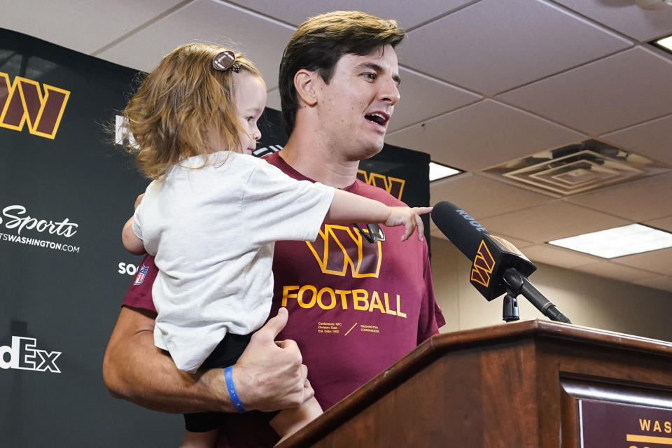 Former Washington player Ryan Kerrigan holds his daughter Hayes Kerrigan as he speaks with reporters about his recent retirement at the Washington Commanders' NFL football training facility, Saturday, July 30, 2022 in Ashburn, Va. (AP Photo/Alex Brandon)