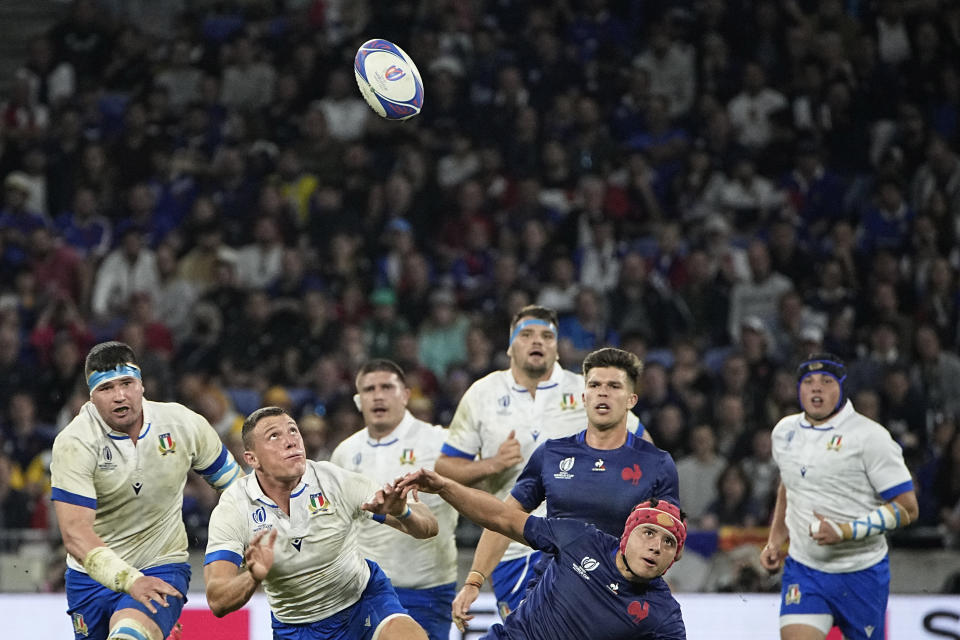 Italy's Paolo Garbisi, left, chases the ball with France's Louis Bielle-Biarrey during the Rugby World Cup Pool A match between France and Italy at the OL Stadium, in Lyon, France Friday, Oct. 6, 2023. (AP Photo/Laurent Cipriani)