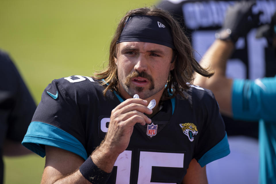 FILE - In this Sept. 20, 2020, file photo, Jacksonville Jaguars quarterback Gardner Minshew (15) walks in the bench area during an NFL football game against the Tennessee Titans in Nashville, Tenn. Quarterback facial hair is sure to be front and center when the Jacksonville Jaguars (1-1) host the Miami Dolphins (0-2) on Thursday night, Sept. 24, 2020. Miami’s Ryan Fitzpatrick has a bushy beard that covers much of his face and engulfs his chin strap; Jacksonville’s Gardner Minshew has a unkept horseshoe mustache that seems to go perfectly with his flowing locks. (AP Photo/Brett Carlsen, File)