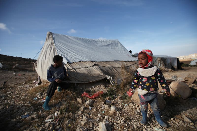 Children paly in the sun on a cold winter day at a camp for internally displaced people in Khamir of the northwestern province of Amran