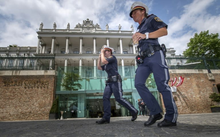 Austrian police officers walk past the Palais Coburg Hotel in Vienna, hosting the Iran nuclear talks