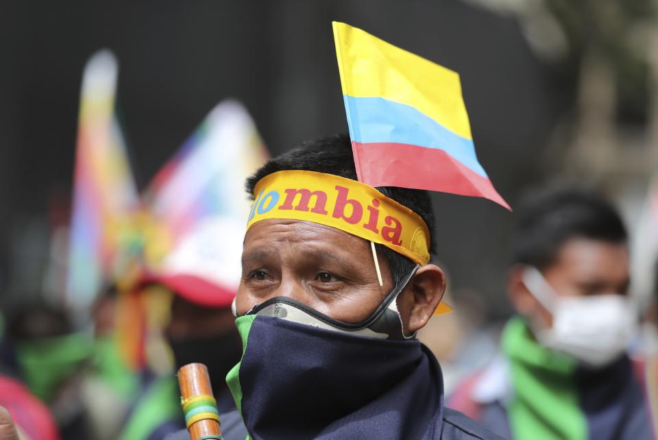 An Indigenous man marches against the government’s handling of a wide range of issues including the economic fallout of the pandemic and implementation of the peace accord, in Bogota, Colombia, Wednesday, Oct. 21, 2020. Indigenous leaders, students and union members gathered in Plaza Bolivar waving flags and banners decrying the government nearly one year after massive protests rocked the country only to fizzle with little to show by way of reform. (AP Photo/Fernando Vergara)