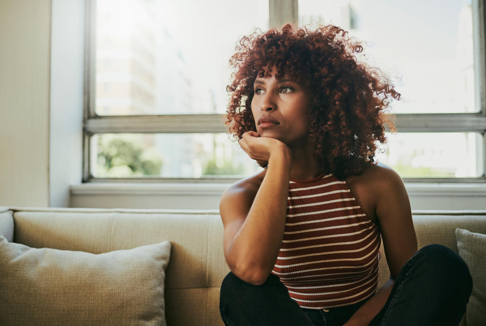 Mental health, thinking and relax with black woman on sofa for depression, lonely and anxiety. Stress, problem and burnout with girl and relax in living room at home for frustrated, failure and sad