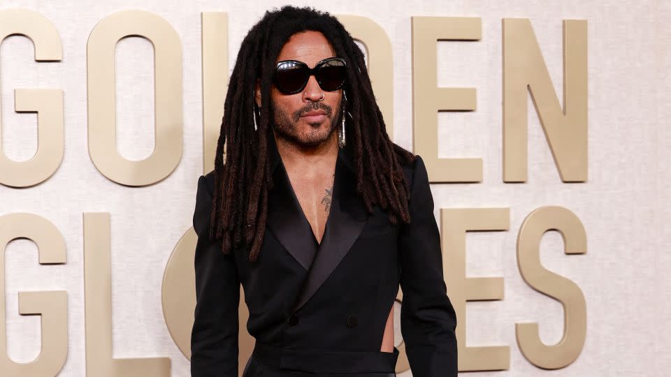 American singer Lenny Kravitz looked suave in a black Alexander McQueen tuxedo jumpsuit, Christian Louboutin shoes, Chrome Hearts diamond and gold rings and vintage ‘70s gold mesh earrings. - Michael Tran/AFP/Getty Images