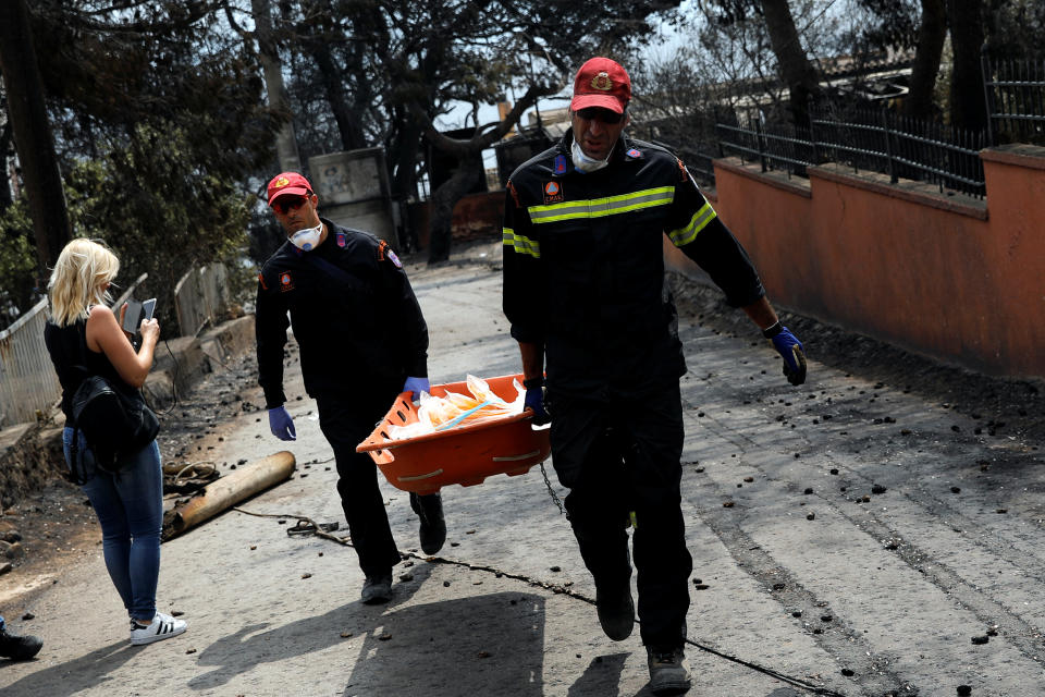 <p>Firefighters carry a stretcher filled with body bags, following a wildfire at the village of Mati, near Athens, Greece, July 24, 2018. (Photo: Alkis Konstantinidis/Reuters) </p>