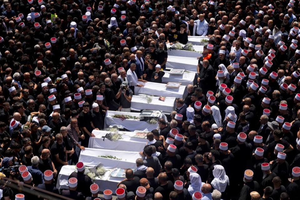 GOLAN HEIGHTS, - JULY 28: Mourners attend a funeral for ten of the victims of yesterday's rocket attack on July 28, 2024 in Majdal Shams, Golan Heights. Yesterday, 12 young people were killed in a rocket attack on a football pitch in this Druze Arab community. Israel blamed the militant group Hezbollah, with which it has been regularly exchanging fire across the Lebanese border, although the group denied responsibility. Today, Israel said it had retaliated with strikes against Hezbollah targets "deep inside Lebanese territory." (Photo by Amir Levy/Getty Images)