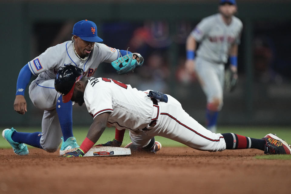 Atlanta Braves' Michael Harris II (23) beats the tag from New York Mets shortstop Francisco Lindor (12) on an RBI double in the sixth inning of a baseball game, Wednesday, June 7, 2023, in Atlanta. (AP Photo/John Bazemore)