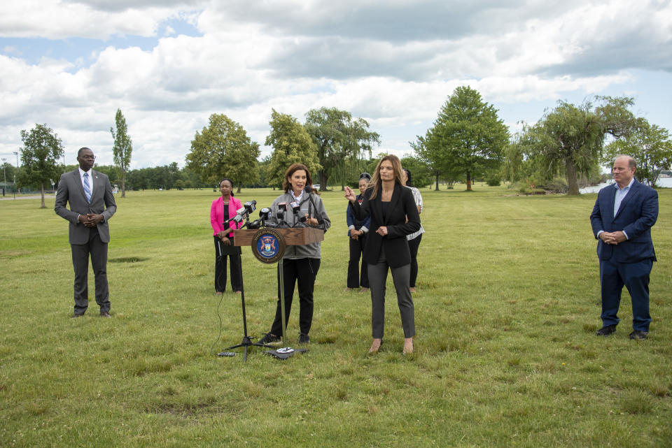 Michigan Gov. Gretchen Whitmer, center, speaks during a press conference on Belle Isle in Detroit, on Tuesday, June 22, 2021, announcing the end of COVID restrictions in the state. After facing 15 months of capacity restrictions and being hit by the country’s worst surge of coronavirus infections this spring, restaurants, entertainment businesses and other venues can operate at 100% occupancy starting Tuesday. (David Guralnick/Detroit News via AP)