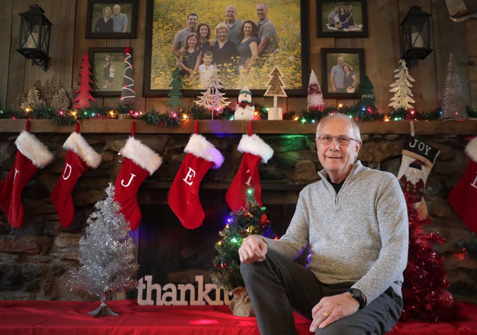 Lee Hillstrom sits with some of the decorative Christmas trees that he and his wife have collected in the past three years.