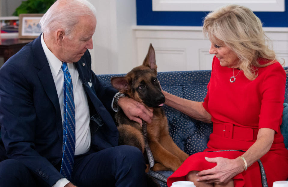 The First couple sitting on a couch with one of their dogs