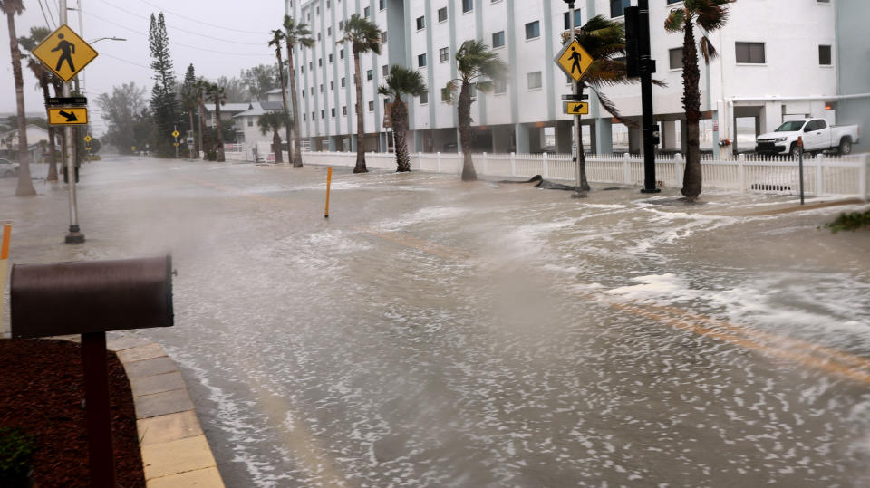 Water from the Gulf of Mexico floods a road as Hurricane Helene churns offshore.