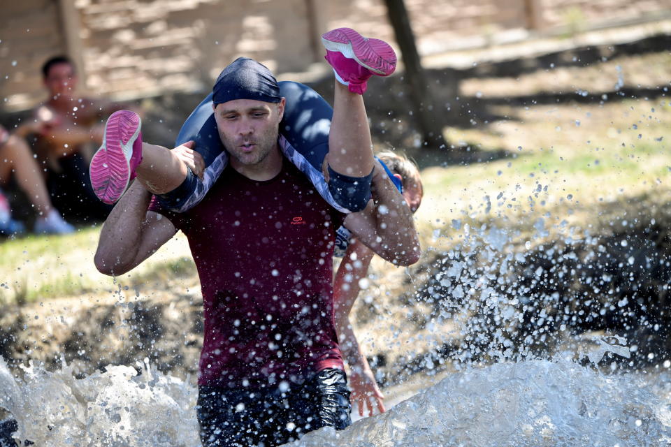 Participants compete in a wife-carrying championship in Tapiobicske, Hungary, August 7, 2021. REUTERS/Marton Monus