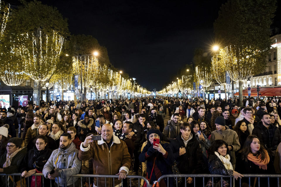 Spectators gather to attend the Champs Elysee Avenue illumination ceremony for the Christmas season, in Paris, Sunday, Nov. 20, 2022. (AP Photo/Lewis Joly)
