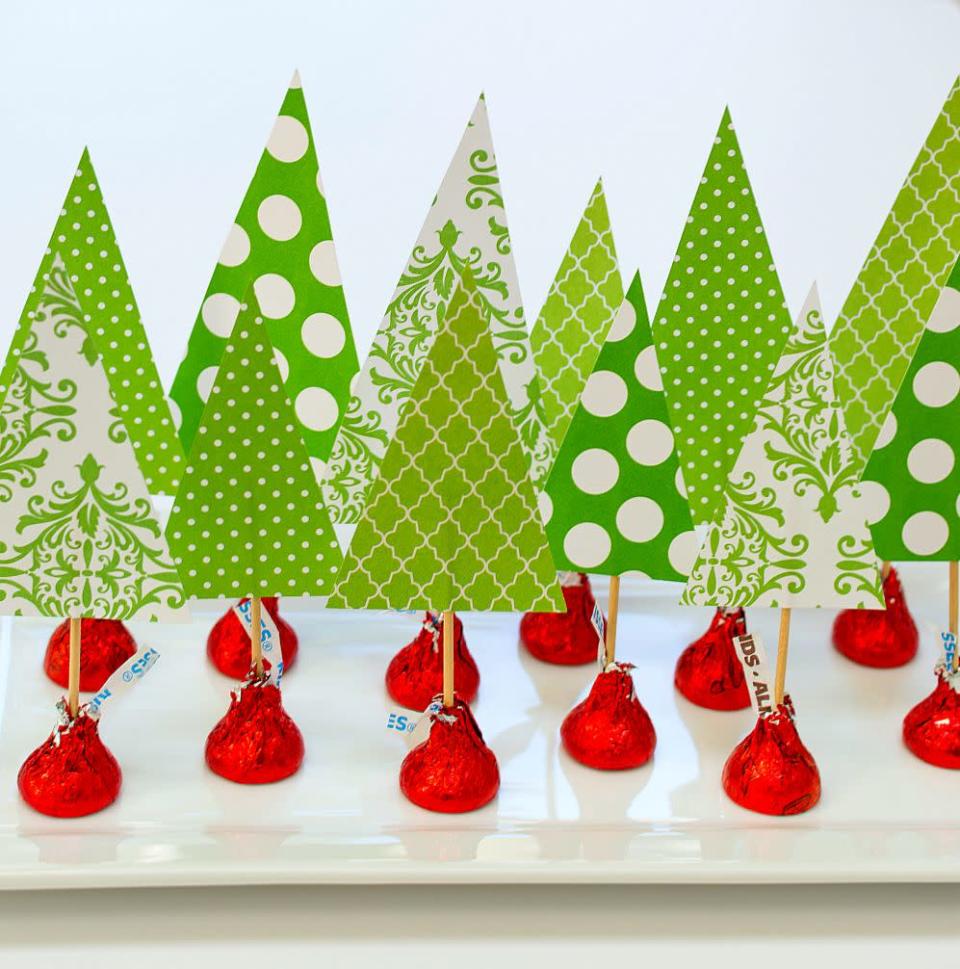 <p>Use Hershey Kisses wrapped in holiday-color foils to make this ultra-easy project: Cut triangles from scrapbooking paper to represent trees, and let kids poke them into the top of the Kisses with toothpicks. Arrange them on a platter for a table centerpiece that's homemade, affordable… and delicious, too.</p><p><em><a href="https://www.itallstartedwithpaint.com/christmas-crafts-with-kids-kisses/" rel="nofollow noopener" target="_blank" data-ylk="slk:Get the tutorial at It All Started With Paint »" class="link rapid-noclick-resp">Get the tutorial at It All Started With Paint »</a></em></p>