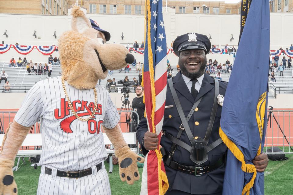 Paterson Police Honor Guard member Kerick Campbell with the Jackals mascot before the ribbon cutting. After years of neglect and abandonment Hinchliffe Stadium is being unveiled at a ribbon cutting in Paterson, NJ on Friday May 19, 2023. 