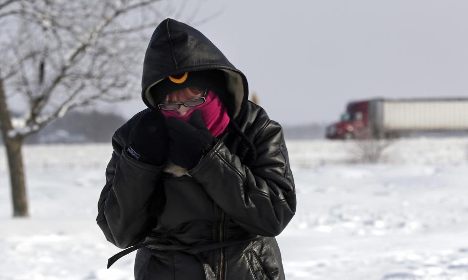 Megan Draper of Noblesville, Indiana covers her face to stay warm north of Indianapolis, Indiana