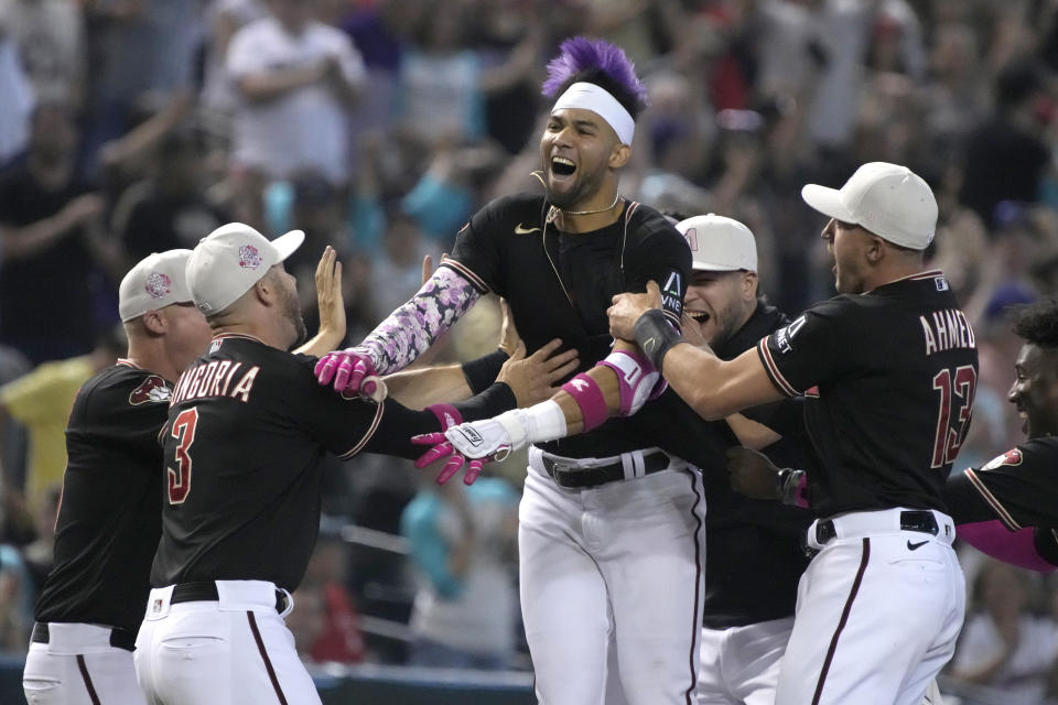 Arizona Diamondbacks' Lourdes Gurriel Jr., center, celebrates with teammates after hitting a walkoff double in the ninth inning during a baseball game against the San Francisco Giants, Sunday, May 14, 2023, in Phoenix. (AP Photo/Rick Scuteri)