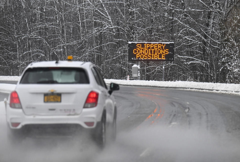 A roadway caution sign is seen as motorists commute during a winter snow storm Tuesday, March 14, 2023, in Albany, N.Y. (AP Photo/Hans Pennink)
