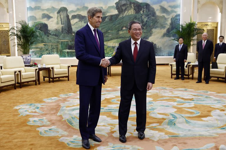 El representante especial de clima John Kerry, a la izquierda, y el primer ministro de China, Li Qiang, se estrechan la mano antes de una reunión en el Gran Salón del Pueblo en Beijing el martes 18 de julio de 2023. (Florence Lo/Pool Foto via AP)