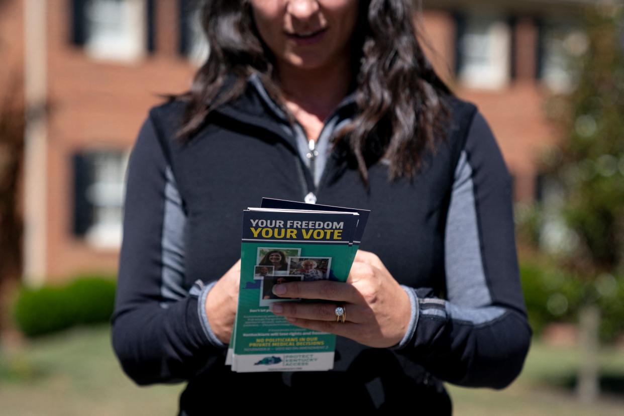 A volunteer with Protect Kentucky Access carries brochures with information on Kentucky's Amendment 2.