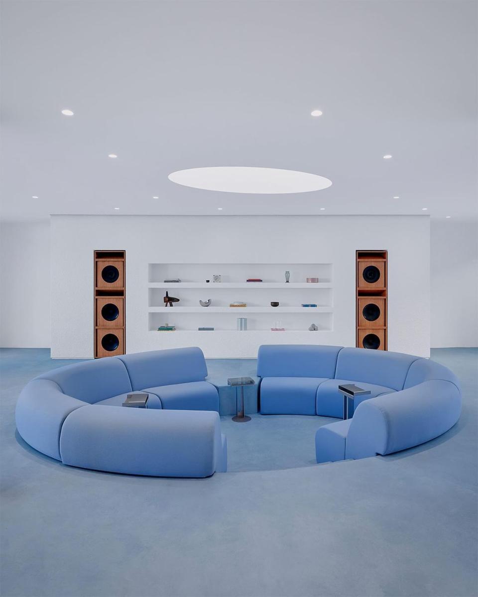 a room with blue couches and a shelf with objects on it