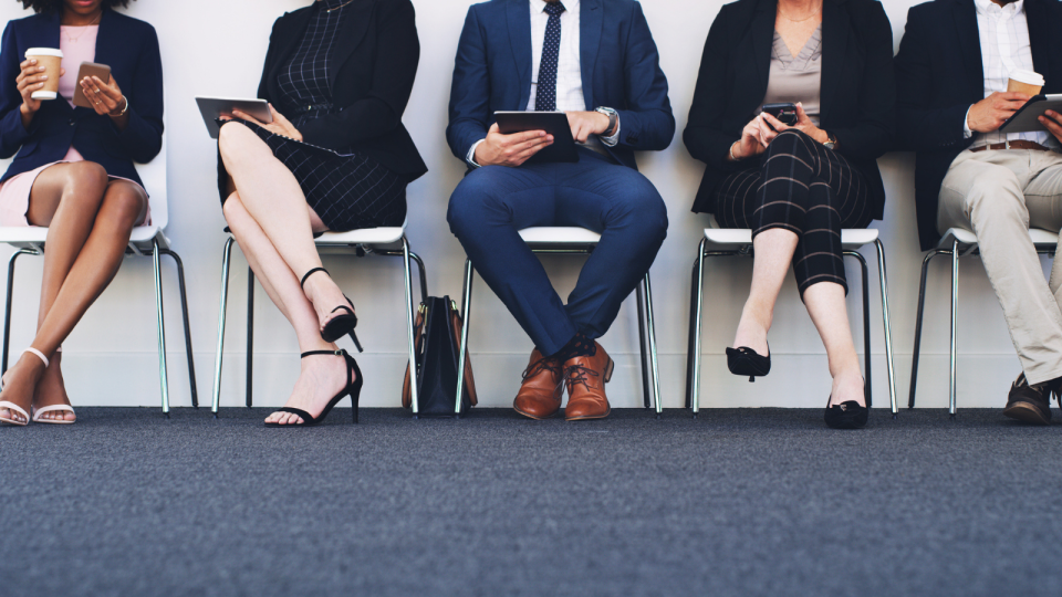 Men and women sit while waiting for job interview. 