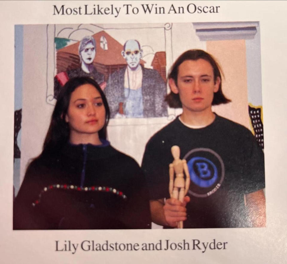 A young Lily Gladstone and Josh Snyder hold a wooden statue in front of a mural. (Courtesy Josh Ryder)