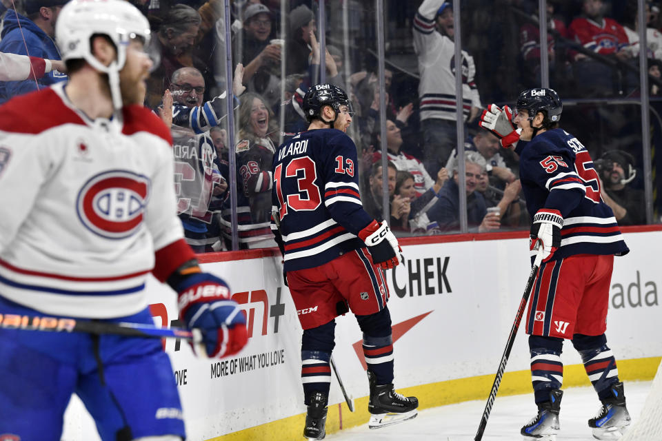 Winnipeg Jets' Gabriel Vilardi (13) celebrates his goal against the Montreal Canadiens with Mark Scheifele (55) during the second period of an NHL hockey game in Winnipeg, Manitoba, Monday, Dec. 18, 2023. (Fred Greenslade/The Canadian Press via AP)