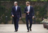 El príncipe Guillermo de Inglaterra, a la izquierda, y su hermano, el príncipe Enrique, llegan para develar una estatua que encargaron de su madre, la princesa Diana, en el que habría sido su 60 cumpleaños, el jueves 1 de julio de 2021 en el Jardín Hundido del Palacio de Kensington, en Londres. (Yui Mok/Pool Photo via AP)