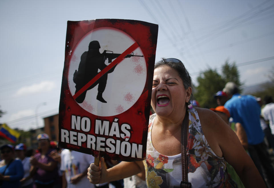 In this Saturday, May 18, 2019 photo, a supporter of Venezuela's opposition leader and self-proclaimed interim president Juan Guaidó holds a poster with the Spanish message: "No more repression" while shouting against the government of Nicolas Maduro at a rally in Guatire, Venezuela. (AP Photo/Ariana Cubillos)