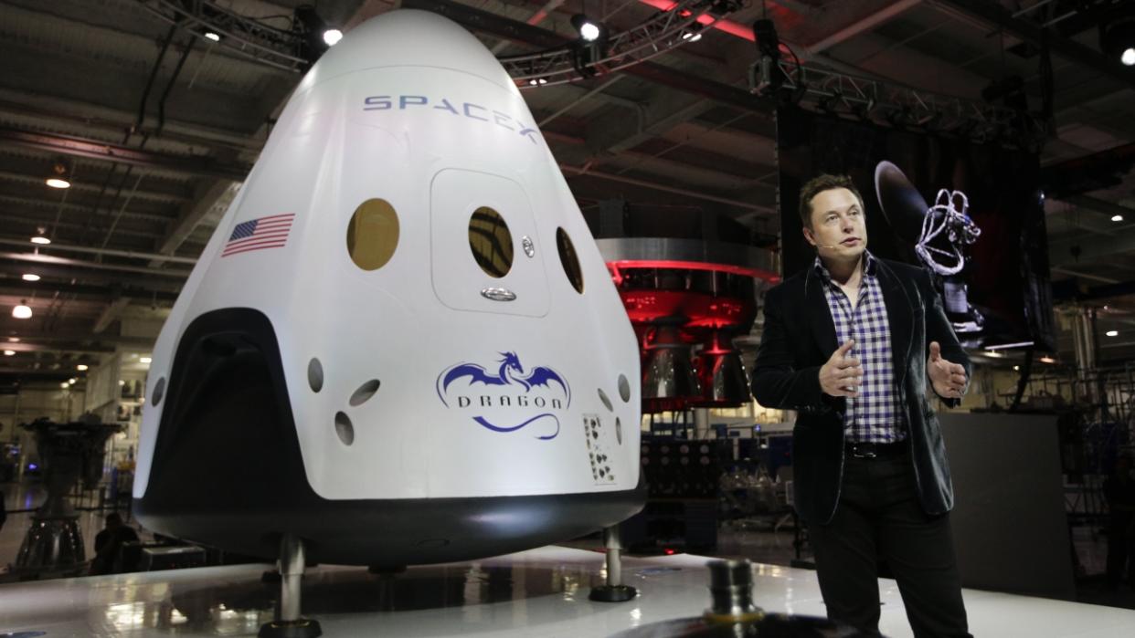 SpaceX CEO Elon Musk in front of the Dragon V2 spaceship.