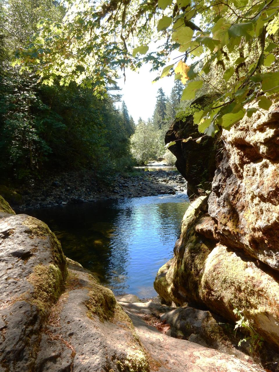 Across from Sharps Creek Recreation Site, a swimming hole sits surrounded by rounded boulders.