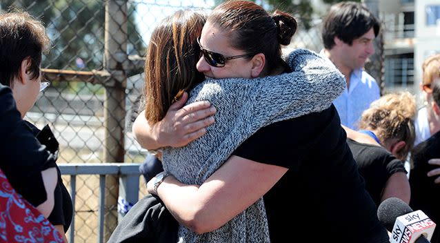 Spotlight employees comfort each other at the crash scene. Picture: AAP