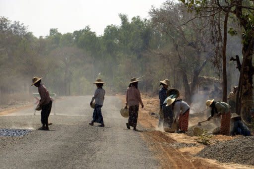Local women are seen repairing a damaged portion of a road between Myanmar's northern city of Bagan and Mandalay, on February 26. Western countries have begun to ease sanctions on Myanmar in response to the the recent promising steps and they are expected to further relax restrictions if April's polls are free and fair