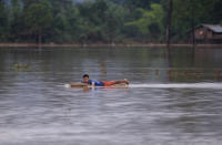 <p>A man swims with matress in flooded village in Sanamxay district, Attapeu province, Laos, Thursday, July 26, 2018. (Photo: Hau Dinh/AP) </p>