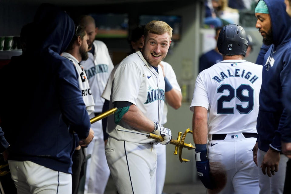 Seattle Mariners' Luke Raley, facing, reacts after breaking the trident used for home run celebrations after he hit a two-run home run against the Kansas City Royals during the second inning of a baseball game, Monday, May 13, 2024, in Seattle. (AP Photo/Lindsey Wasson)