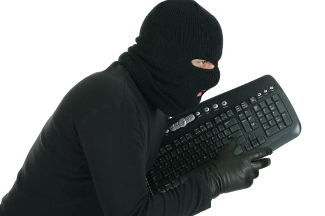 Computer hacker -  masked criminal with keyboard