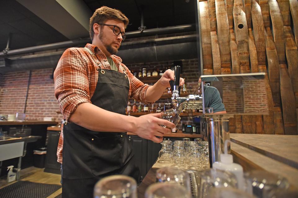 Ian Cardwell pours one of the Phoenix Brewing Company's beers Wednesday afternoon in the new Spirit Room.