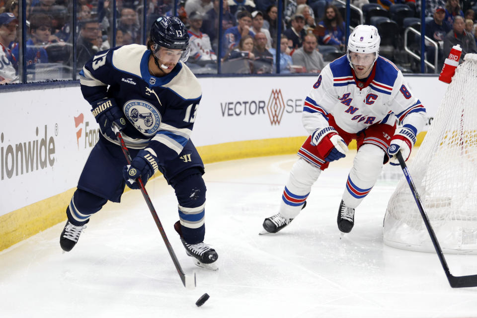 Columbus Blue Jackets forward Johnny Gaudreau, left, controls the puck in front of New York Rangers defenseman Jacob Trouba during the second period of an NHL hockey game in Columbus, Ohio, Saturday, Oct. 14, 2023. (AP Photo/Paul Vernon)