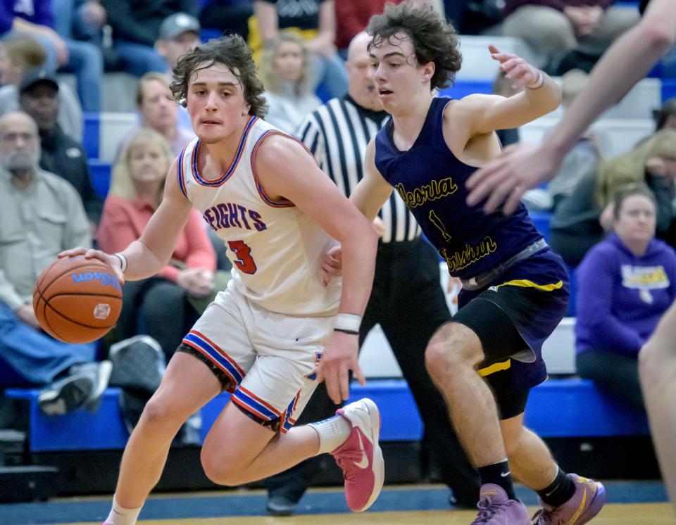 Peoria Heights' Camron Williams, left, moves the ball against Peoria Christian's Malachi Persinger in the second half of their high school basketball game Friday, Jan. 26, 2024 at Peoria Heights High School. The Chargers defeated the Patriots 60-58.