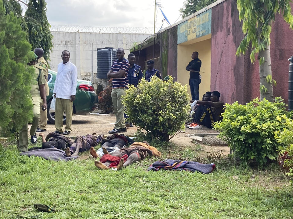 Recaptured inmates lie on the ground in front of the Kuje maximum prison following a rebel attack in Kuje, Nigeria, Wednesday, July 6, 2022. At least 600 inmates escaped in a jailbreak in Nigeria's capital city, officials said Wednesday, blaming the attack on Islamic extremist rebels. About 300 have been recaptured, authorities said. (AP Photo/Chinedu Asadu)