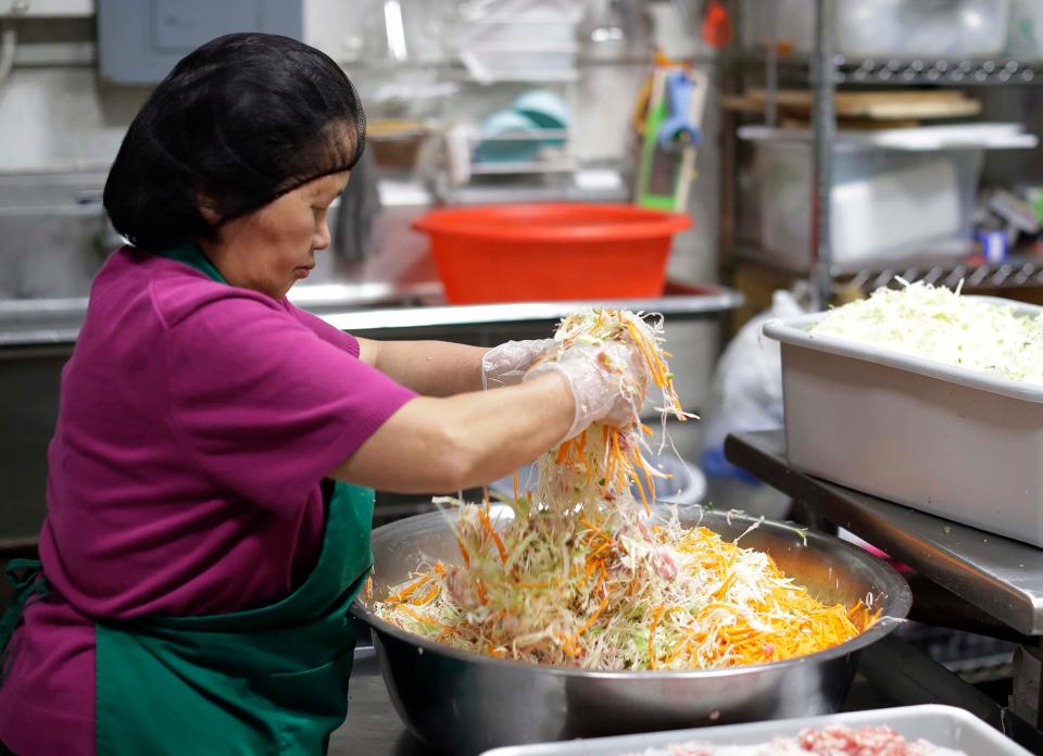 Union Asian Market’s May Yer Xiong, of Sheboygan, hand mixes ingredients for Hmong egg rolls in Sheboygan. The firm found that hand made egg rolls turn out a consistent quality product.